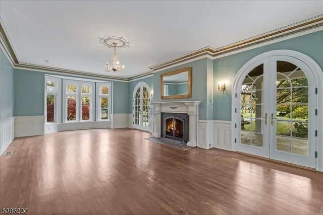 a view of an empty room with a fireplace and wooden floor