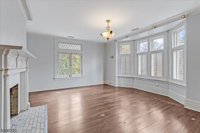 a view of a big house with a big yard and large trees