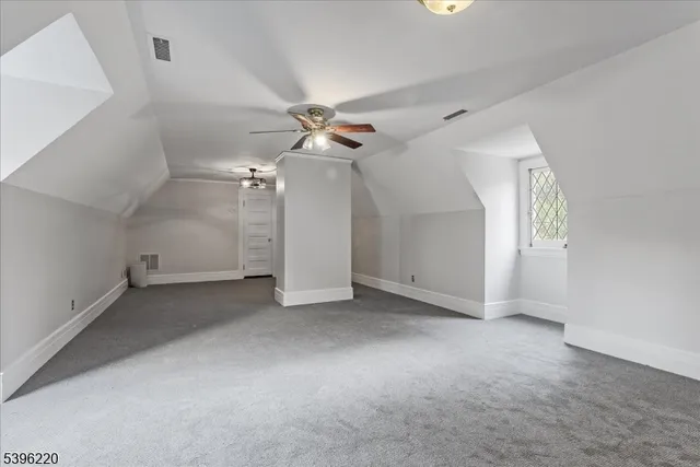 a white house with a big yard and large trees