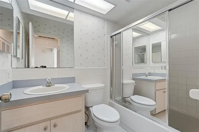 a bathroom with a toilet a sink a mirror and a shower