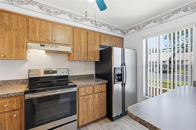 a kitchen with stainless steel appliances a refrigerator sink and stove