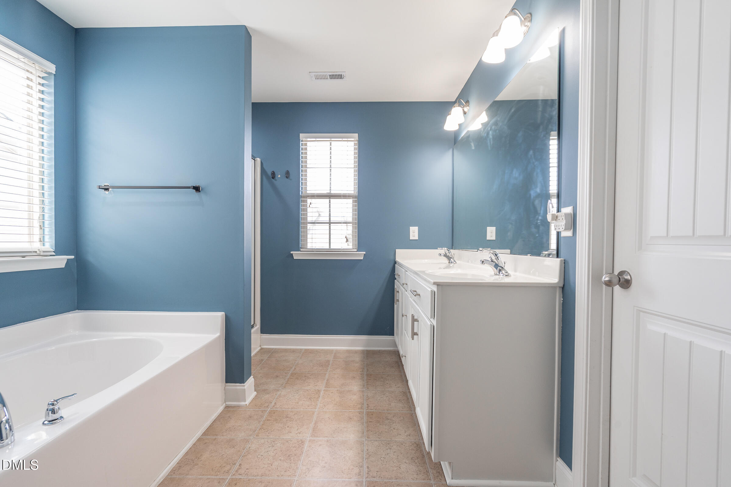 2756 Shepherd Valley Street Raleigh, NC 27610 - Photo 16 of 30 a bathroom with a sink a tub and mirror