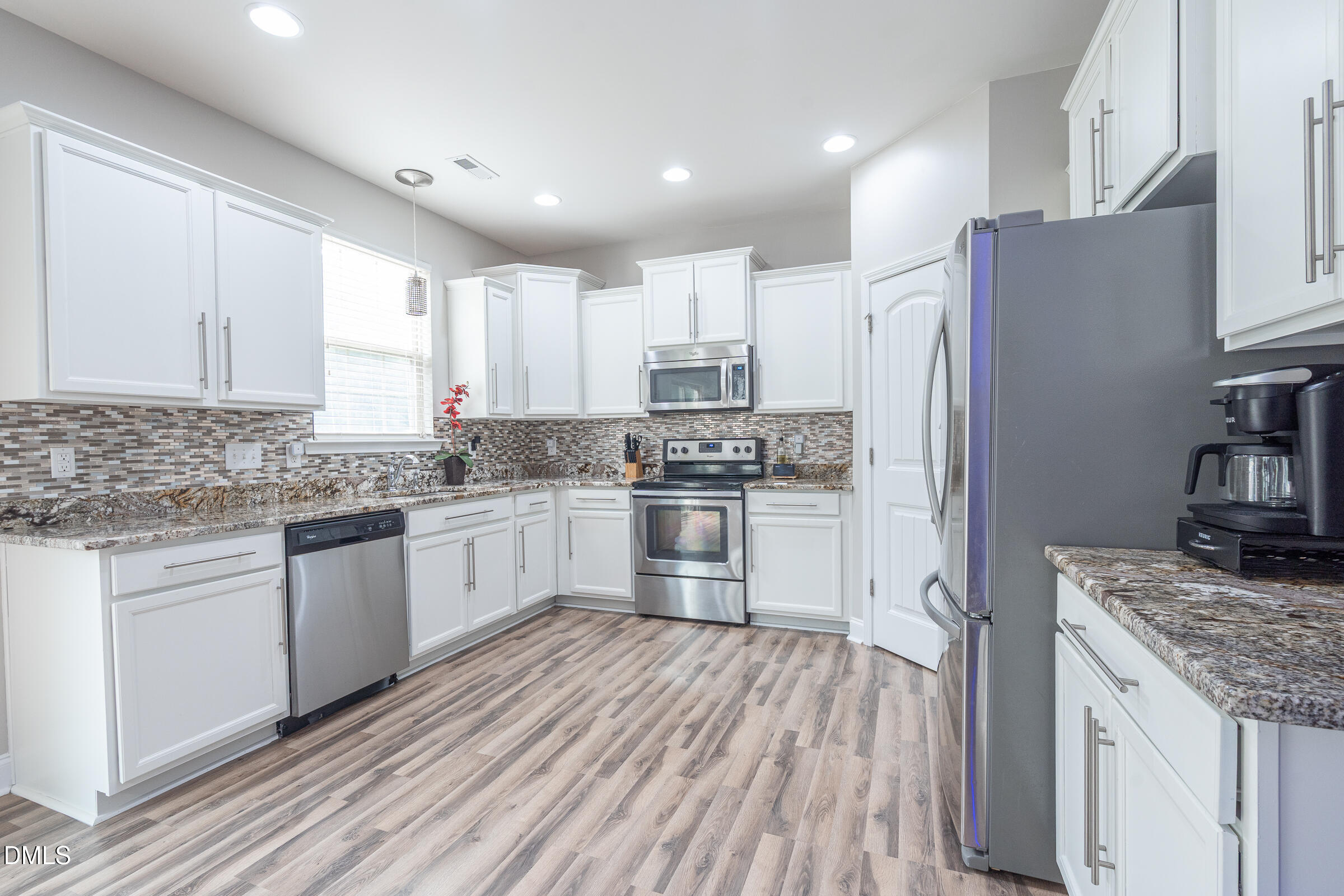 2756 Shepherd Valley Street Raleigh, NC 27610 - Photo 6 of 30 a kitchen with a refrigerator a sink and wooden cabinets