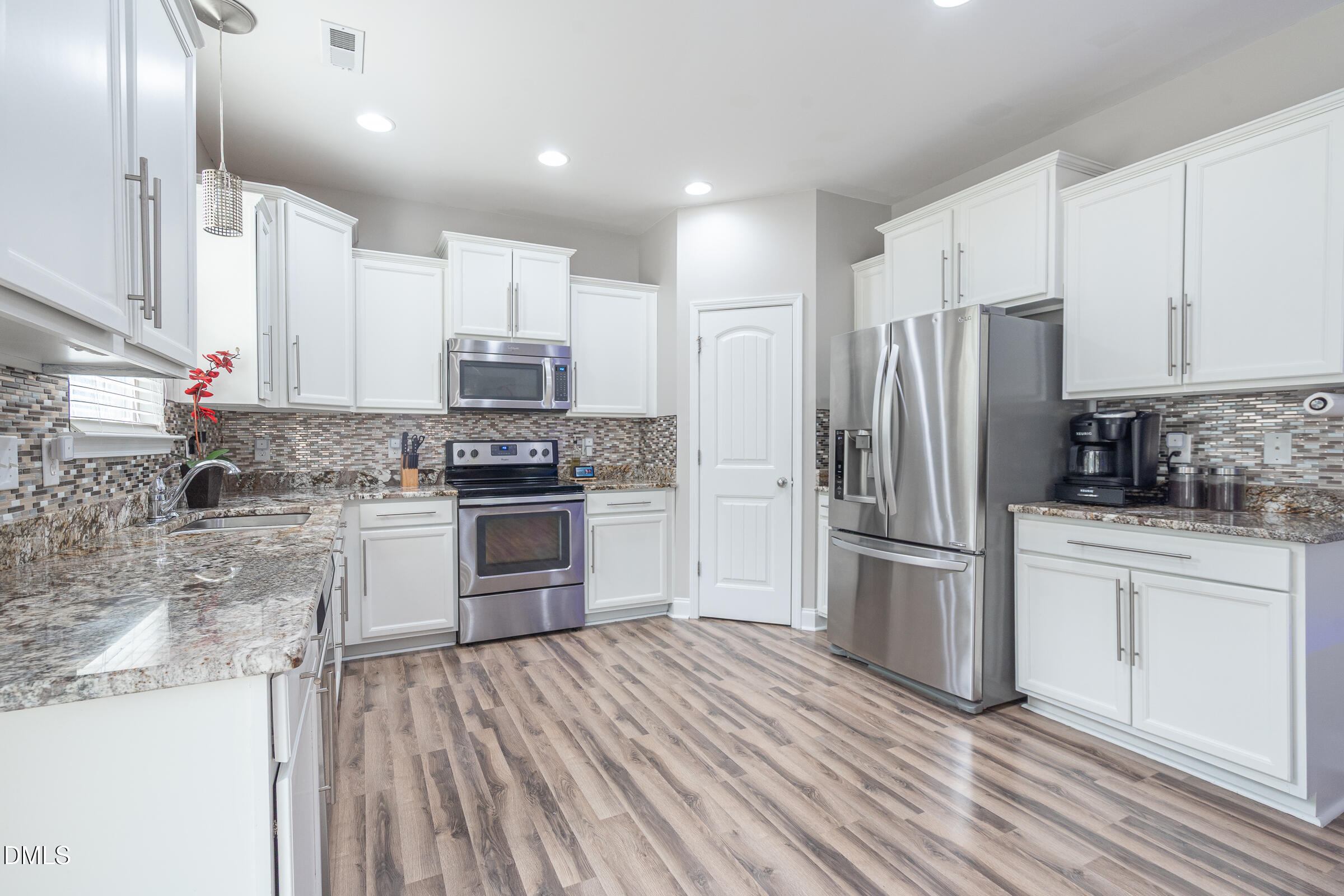 2756 Shepherd Valley Street Raleigh, NC 27610 - Photo 7 of 30 a kitchen with granite countertop a refrigerator stove and oven