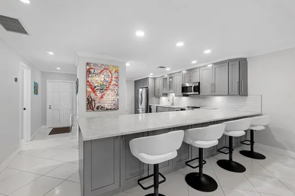 a large kitchen with stainless steel appliances a sink and cabinets