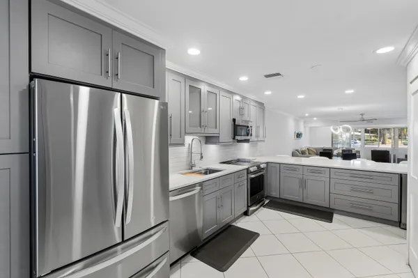 a kitchen with white cabinets stainless steel appliances and a sink