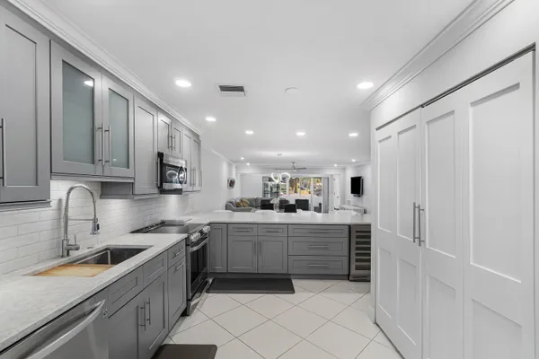 a kitchen with a sink white cabinets and white appliances