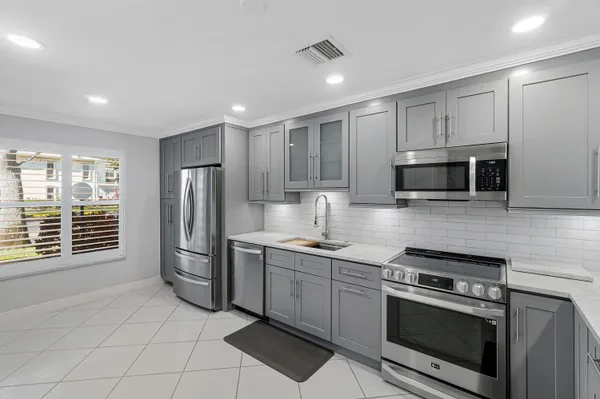 a kitchen with stainless steel appliances granite countertop a stove a sink and a microwave