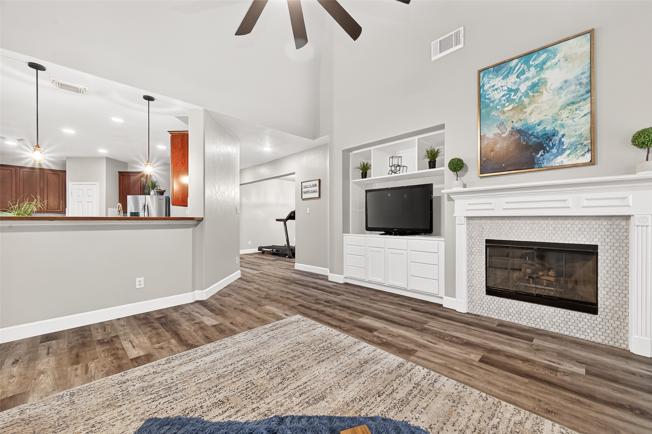 7415 Riven Oaks Court Cypress, TX 77433 - Photo 20 of 42 This view of the living room highlights the cozy fireplace with custom built-in shelving on one side, creating a warm and functional focal point perfect for displaying décor, books, and entertainment.