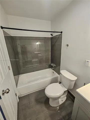 a white toilet and tub next to a bathroom sink
