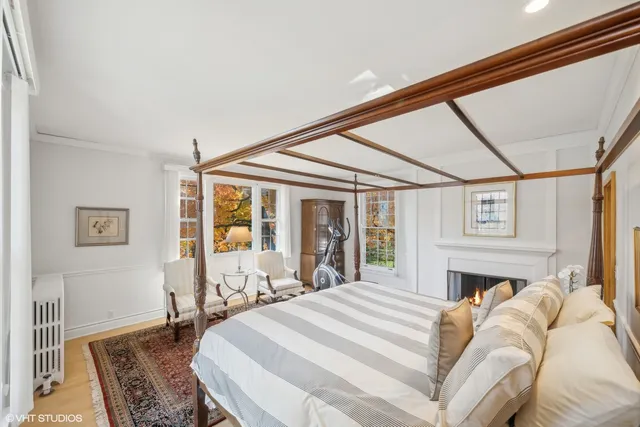 a bed sitting in a bedroom next to a window with a flat screen tv