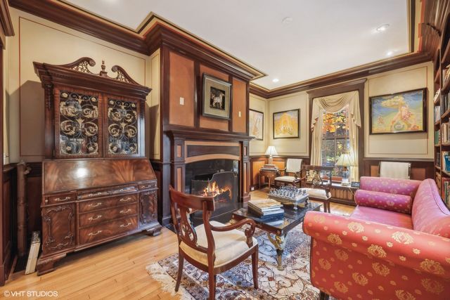 a living room with furniture a large window and a fireplace