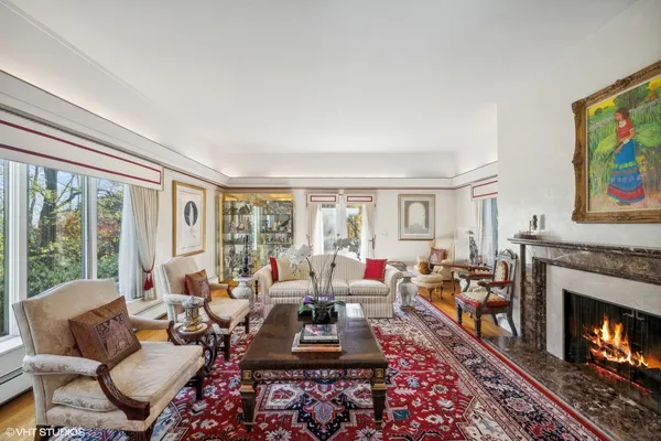 a living room with furniture fireplace and a large window