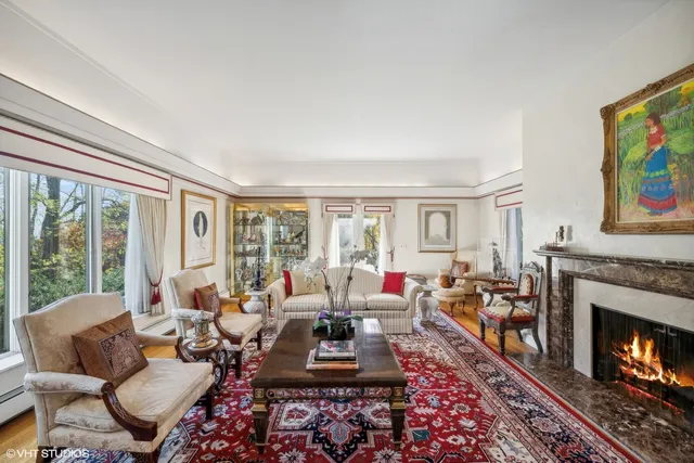 a living room with furniture fireplace and a large window