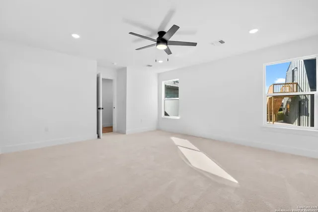 an empty room with closet and windows