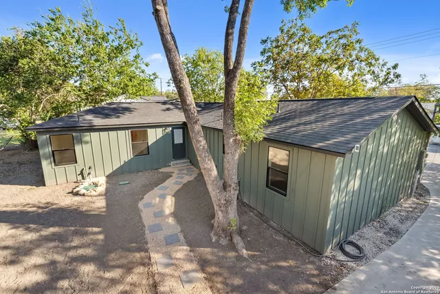 a view of a house with a tree in the background