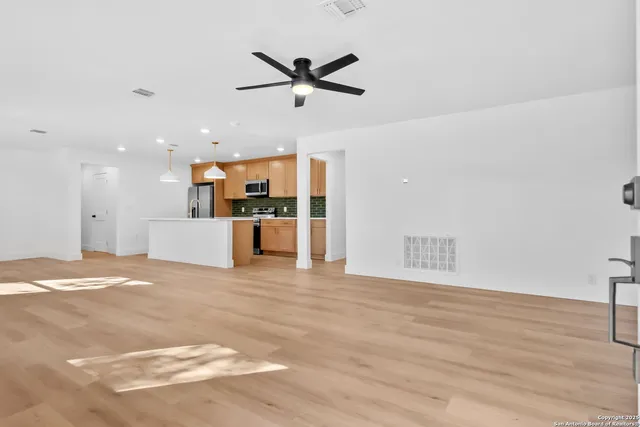 a view of a livingroom with a ceiling fan and wooden floor