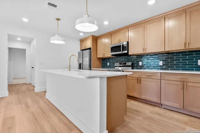 a kitchen with cabinets a sink and appliances
