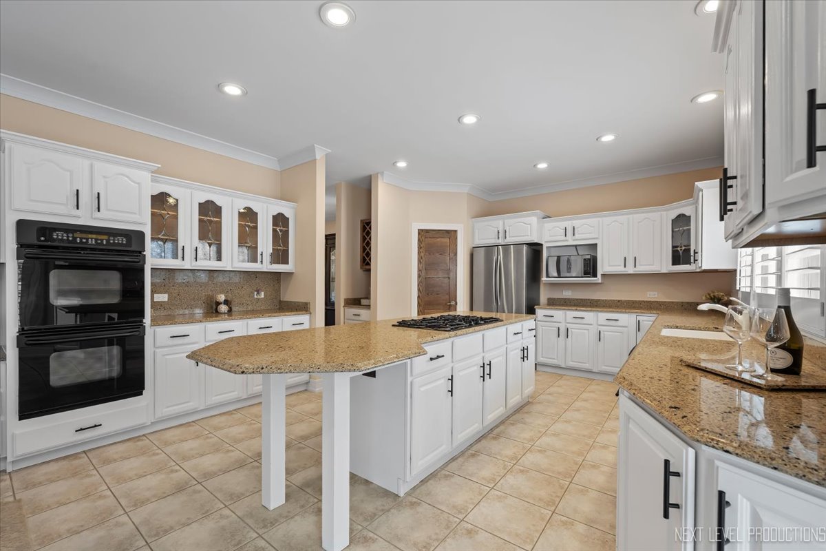 970 Waterside Court Aurora, IL 60502 - Photo 12 of 42 a large kitchen with stainless steel appliances granite countertop a large counter top and a stove top oven