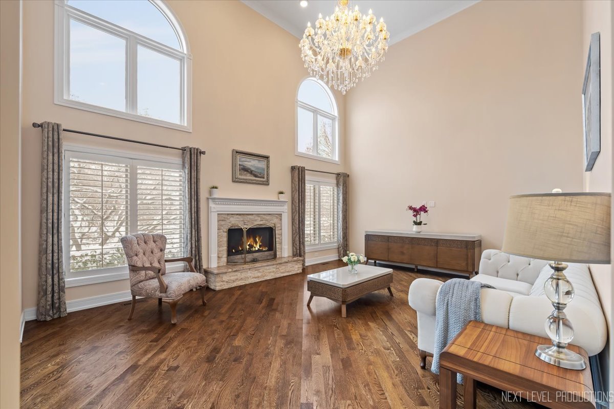 970 Waterside Court Aurora, IL 60502 - Photo 15 of 42 a living room with furniture a fireplace and a chandelier