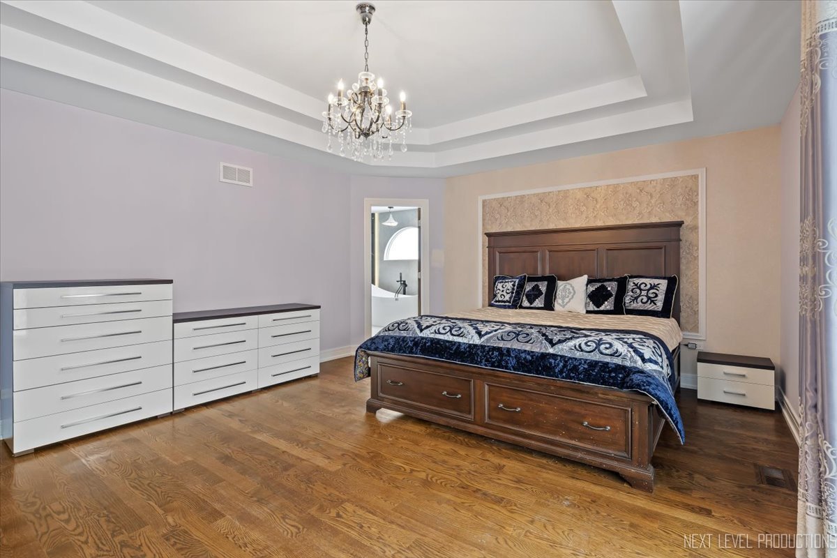 970 Waterside Court Aurora, IL 60502 - Photo 22 of 42 a bedroom with a bed and a chandelier