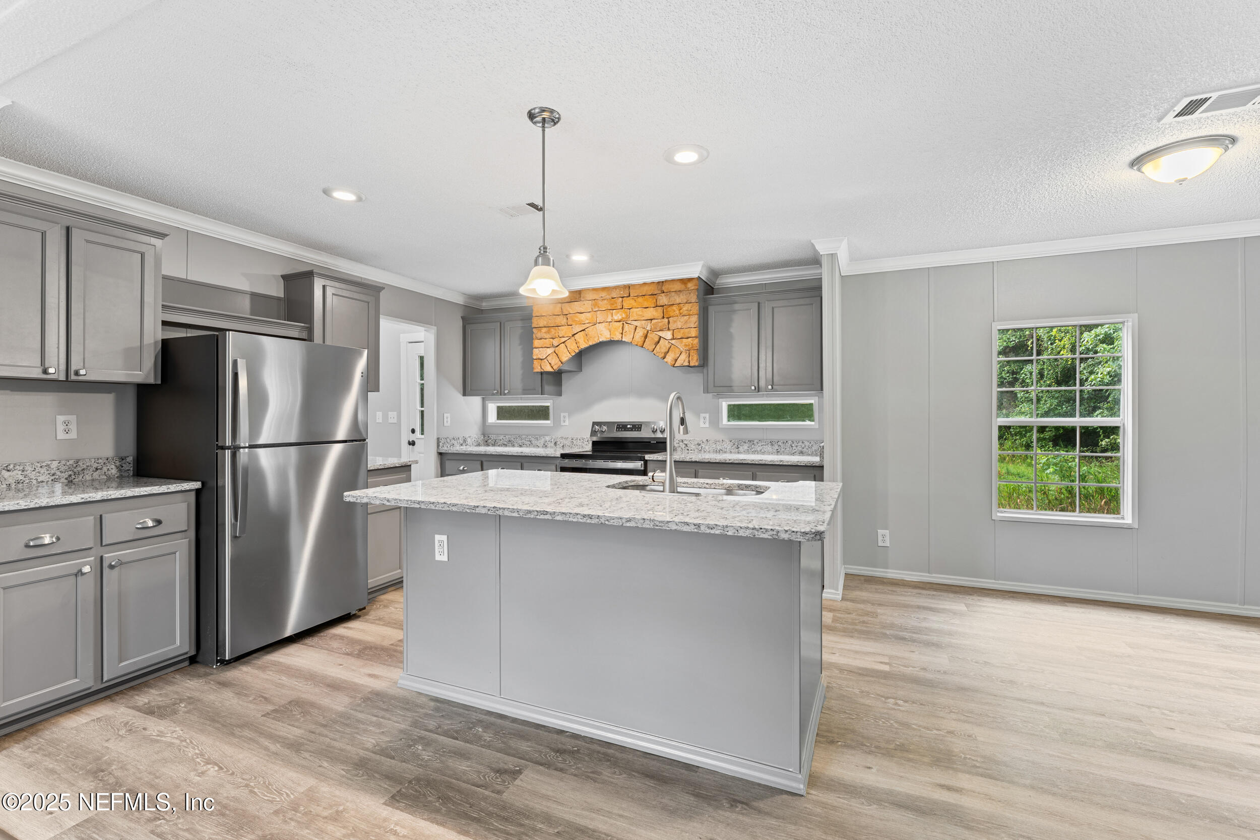 37341 Old Pineridge Road Hilliard, FL 32046 - Photo 8 of 27 a kitchen with stainless steel appliances granite countertop a refrigerator a sink dishwasher a stove and white countertops with wooden floor