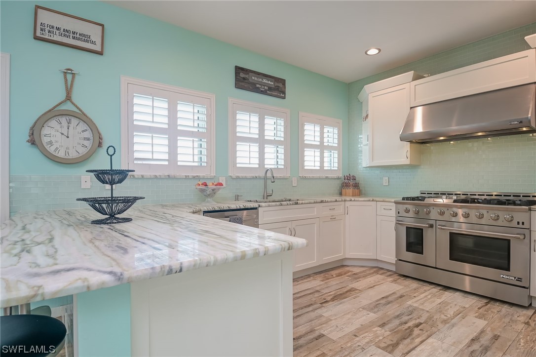 12614 River Road Fort Myers, FL 33905 - Photo 13 of 50 a kitchen with a stove a sink and a wooden cabinets