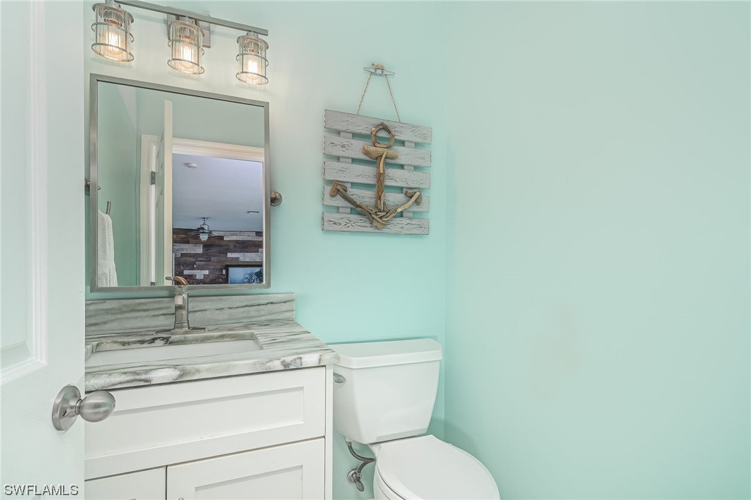 12614 River Road Fort Myers, FL 33905 - Photo 15 of 50 a bathroom with a toilet sink and mirror