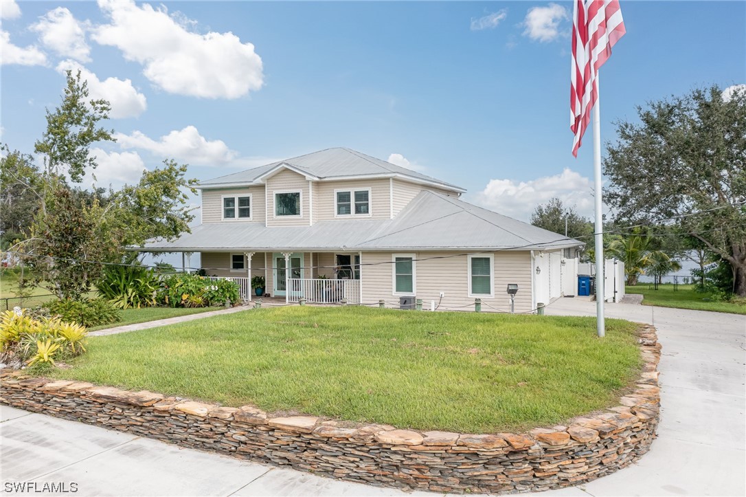 12614 River Road Fort Myers, FL 33905 - Photo 3 of 50 a view of a white house with a big yard and potted plants