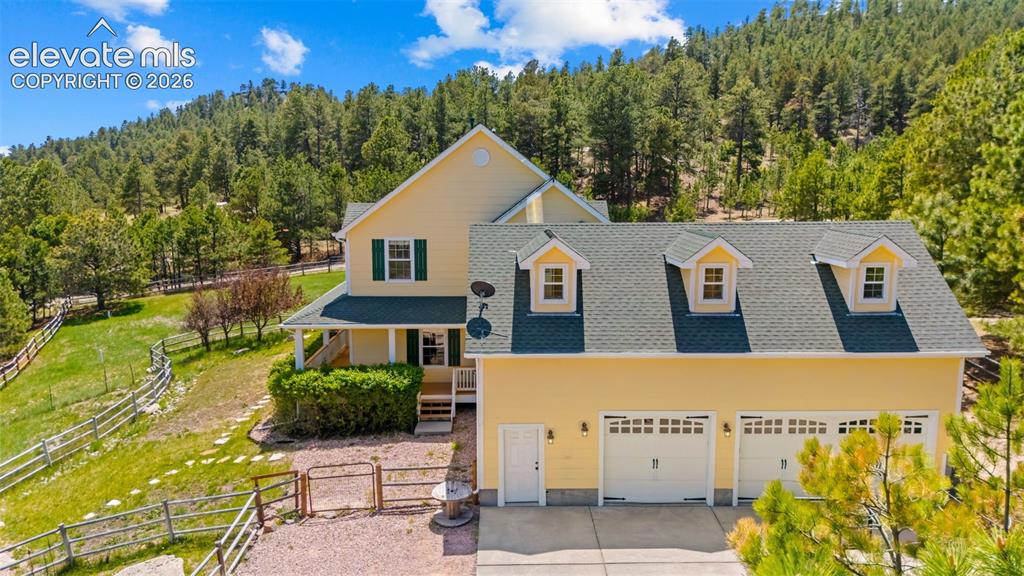 16540 Mesquite Road Peyton, CO 80831 - Photo 3 of 50 a view of a blue house with large windows and plants