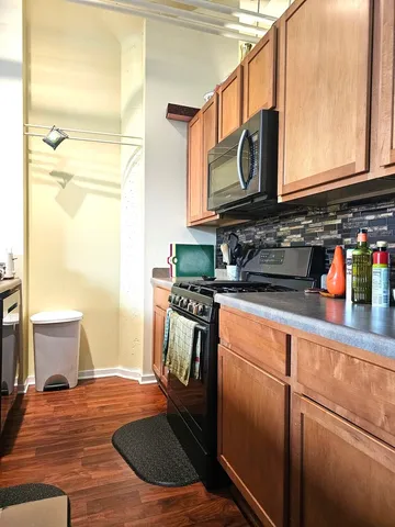 a kitchen with stainless steel appliances granite countertop a sink and a stove next to a window