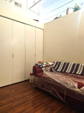a bedroom with a bed and a dresser next to a window