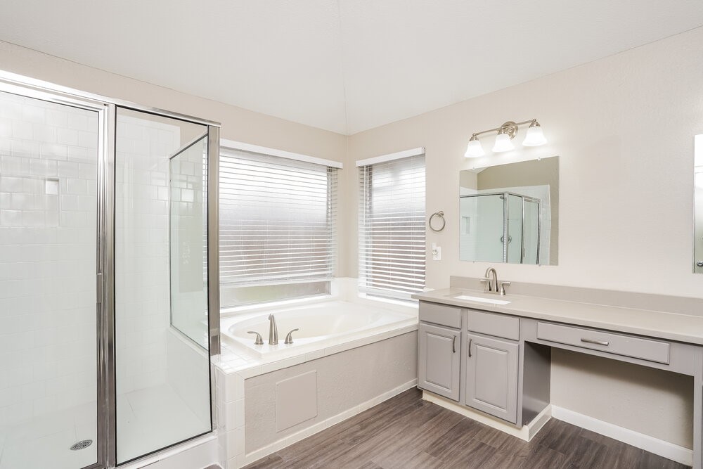8911 Cypress Square Drive Spring, TX 77379 - Photo 11 of 16 a bathroom with a bathtub a sink a mirror and a shower