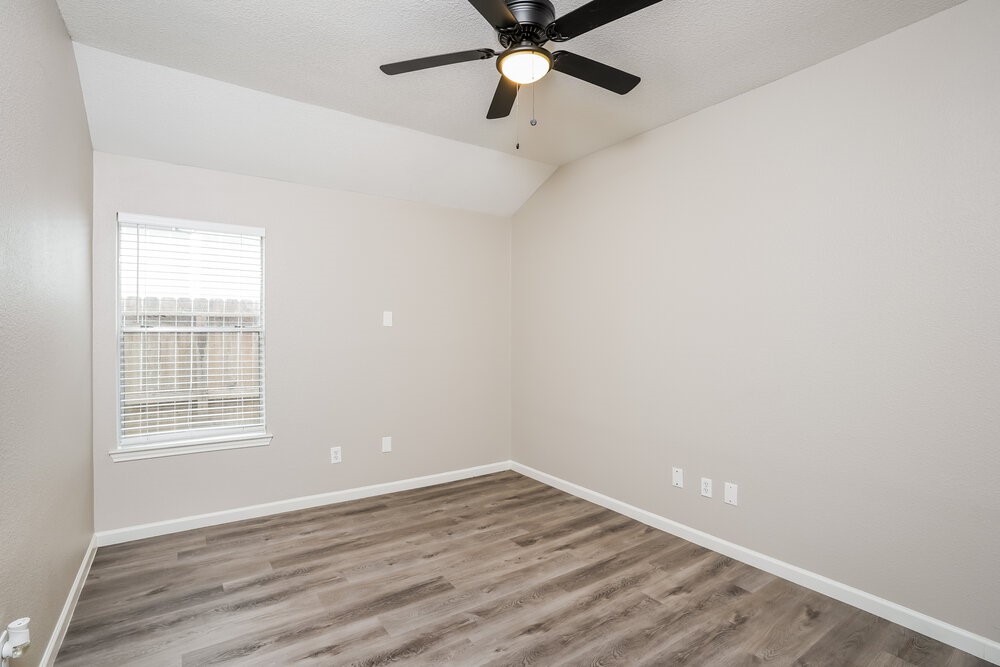 8911 Cypress Square Drive Spring, TX 77379 - Photo 12 of 16 an empty room with wooden floor fan and windows