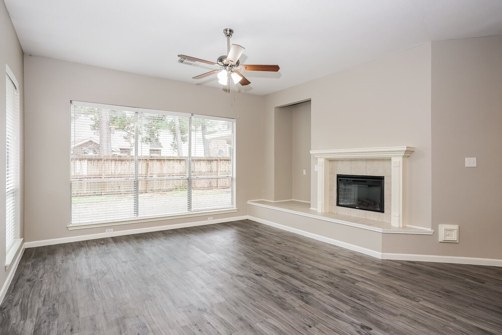 8911 Cypress Square Drive Spring, TX 77379 - Photo 4 of 16 an empty room with wooden floor fan and windows