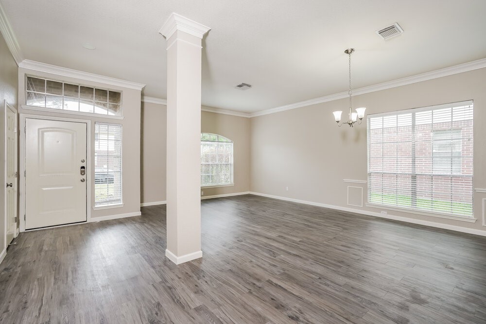 8911 Cypress Square Drive Spring, TX 77379 - Photo 6 of 16 a view of an empty room with wooden floor and a window