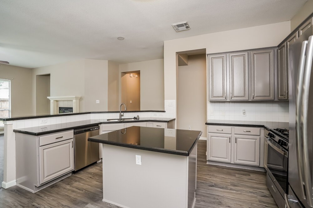 8911 Cypress Square Drive Spring, TX 77379 - Photo 8 of 16 a kitchen with stainless steel appliances granite countertop a sink stove and refrigerator