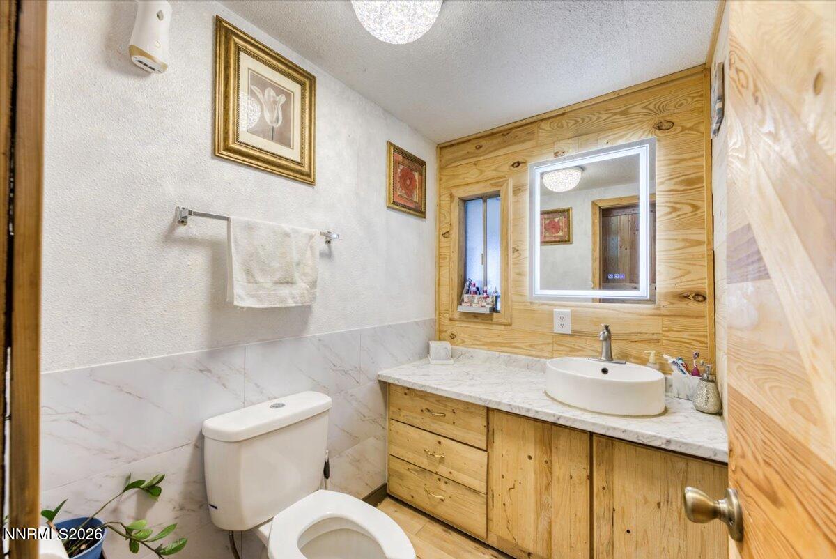985 Villa Way Fernley, NV 89408 - Photo 17 of 37 a bathroom with a granite countertop toilet sink and mirror