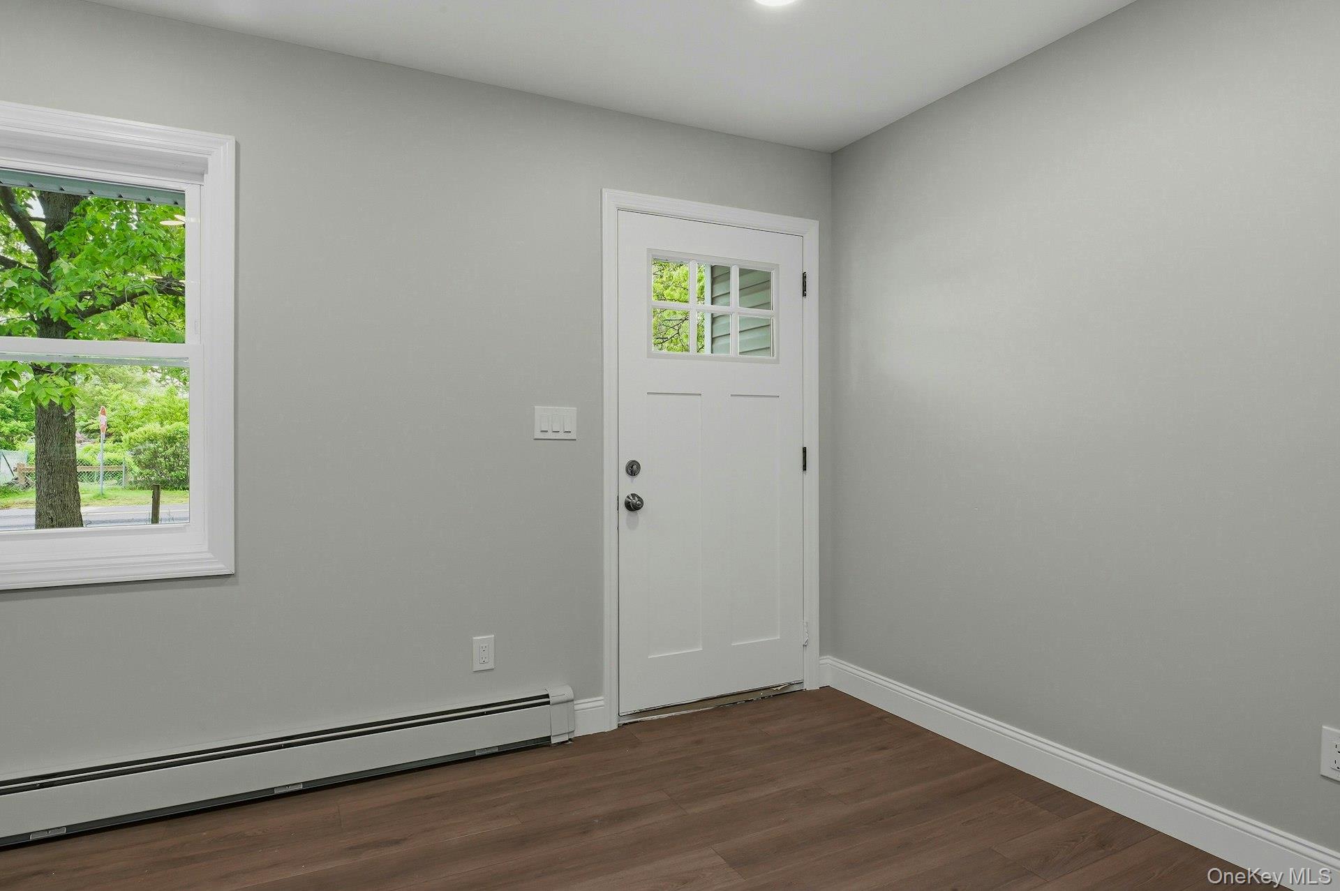 101 Rustic Road Centereach, NY 11720 - Photo 10 of 42 an empty room with wooden floor and windows