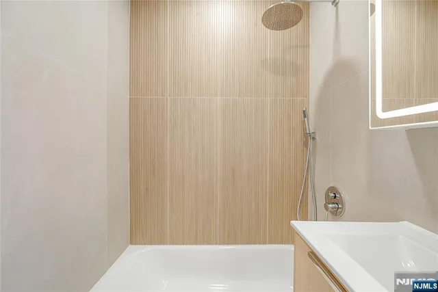 a bathroom with a granite countertop sink and a bathtub