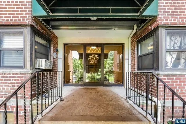 a view of balcony with a large window and potted plants