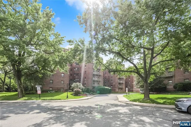 a brick building with a big yard and large trees