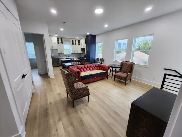 a living room with furniture and a wooden floor