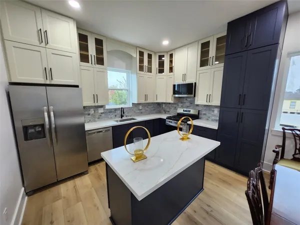 a kitchen with stainless steel appliances granite countertop a sink a refrigerator and a stove