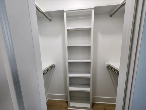 a view of walk in closet with empty racks