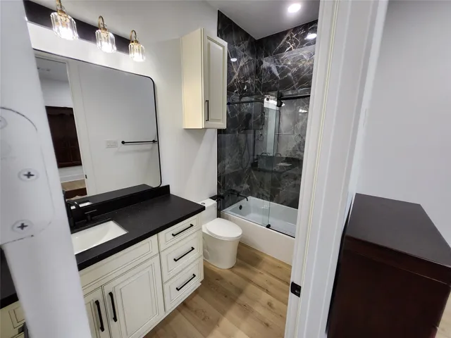 a bathroom with a granite countertop sink toilet and shower