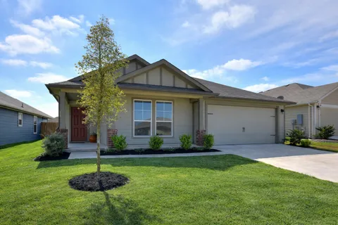 a front view of a house with a yard and plants