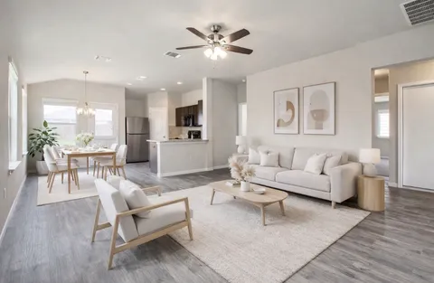 a living room with furniture and a ceiling fan