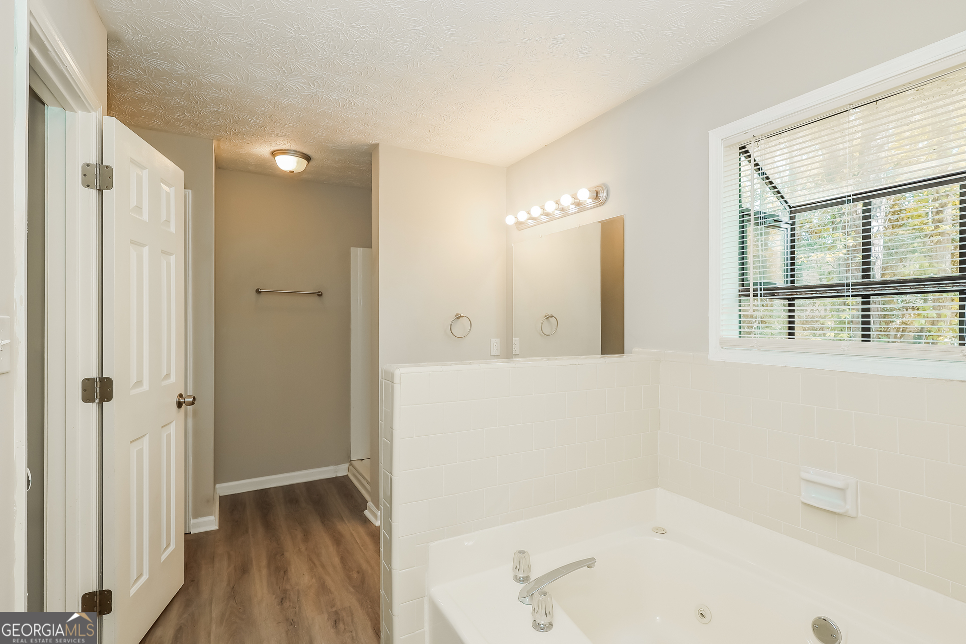 9183 Snipe Lane Jonesboro, GA 30236 - Photo 15 of 22 a bathroom with a bathtub and a shower