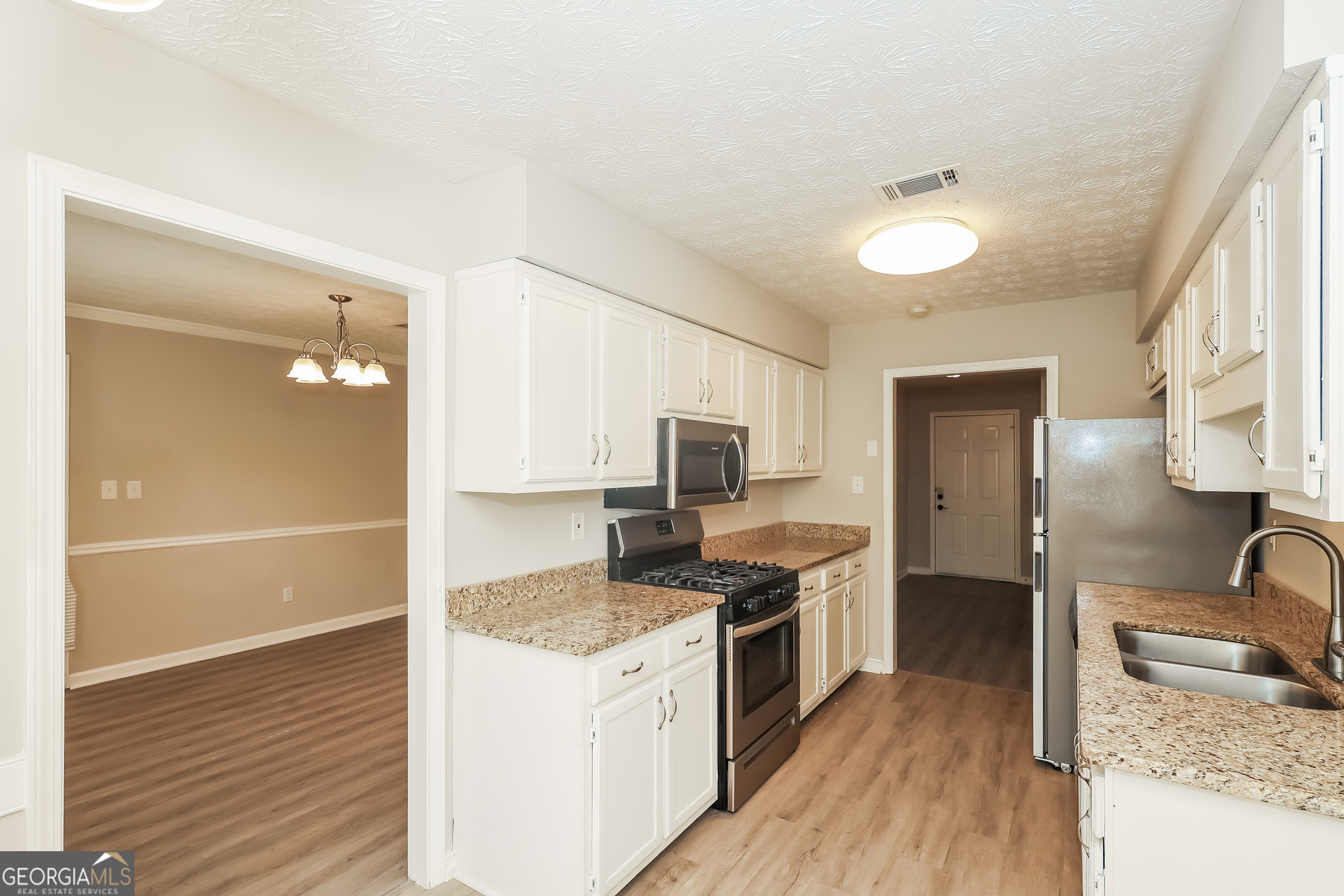 9183 Snipe Lane Jonesboro, GA 30236 - Photo 7 of 22 a kitchen with granite countertop a sink stove and refrigerator